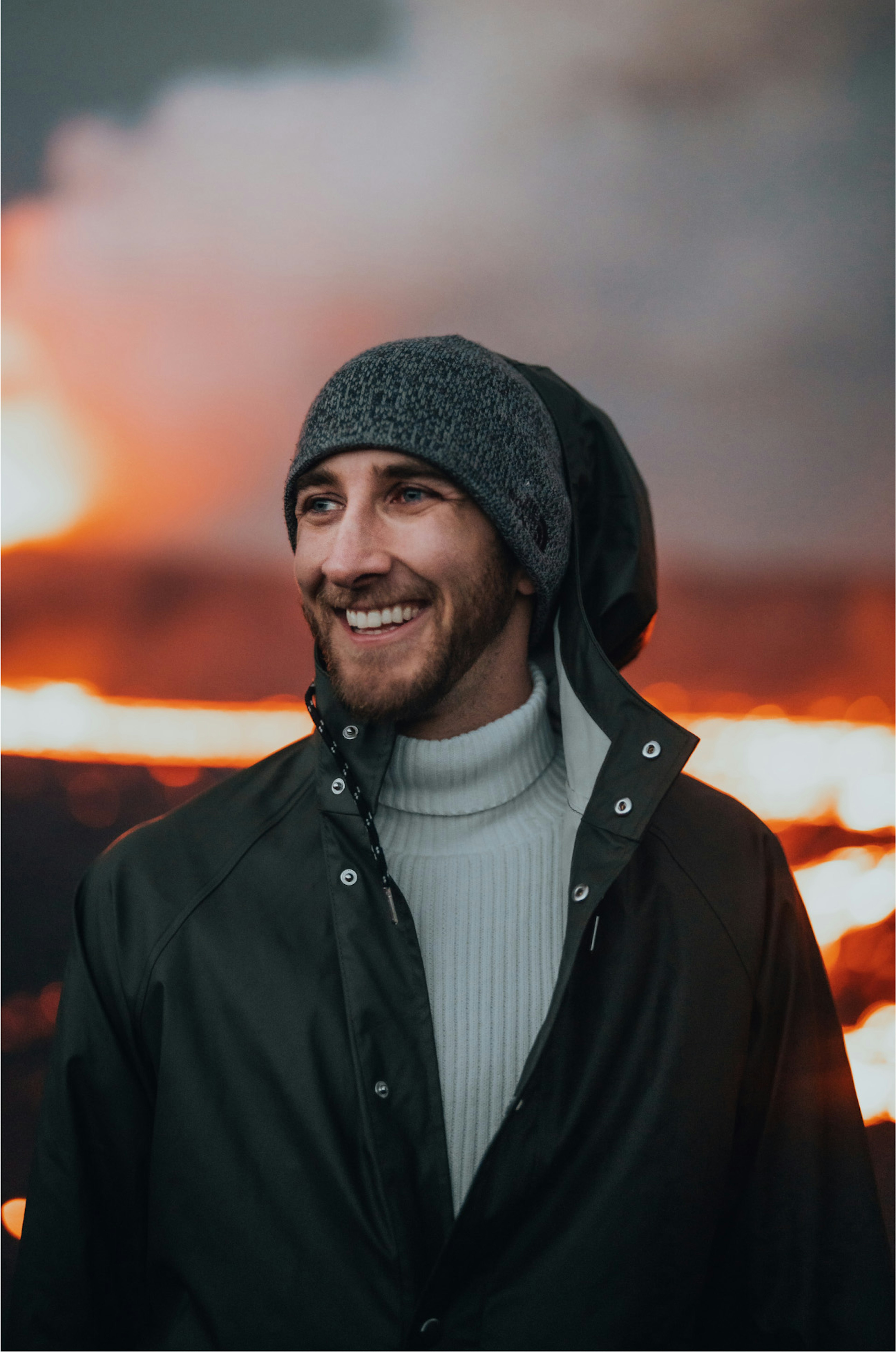 A content creator with long hair focuses on his camera, capturing the scenic beauty of an outdoor landscape, perfect for stock footage